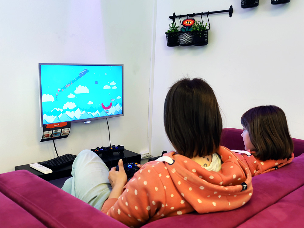 Kinder an einer Konsole spielen gemeinsam bei einem Klassenausflug